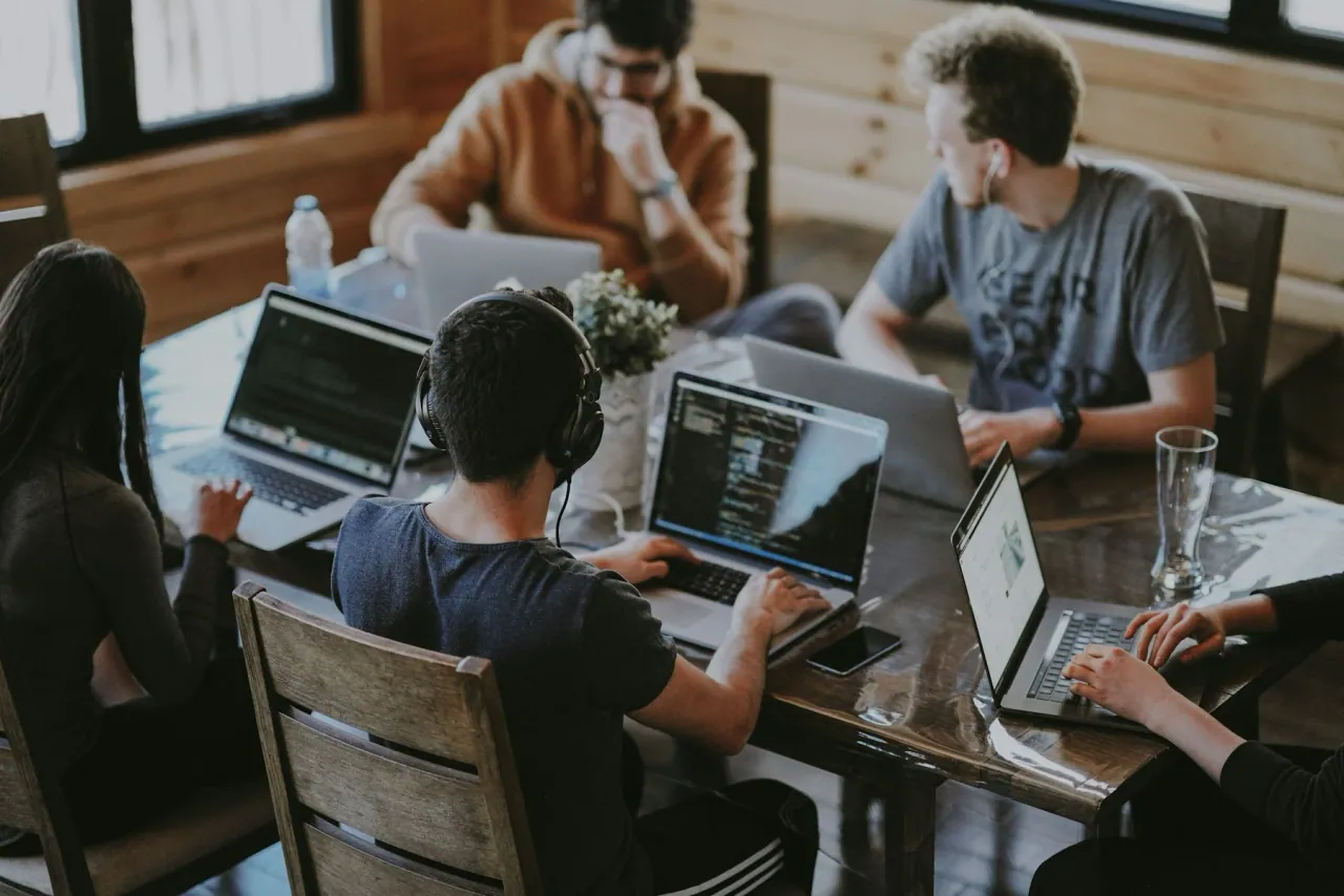 Equipo colaborando frente a un portátil durante el diseño y desarrollo de una página web
